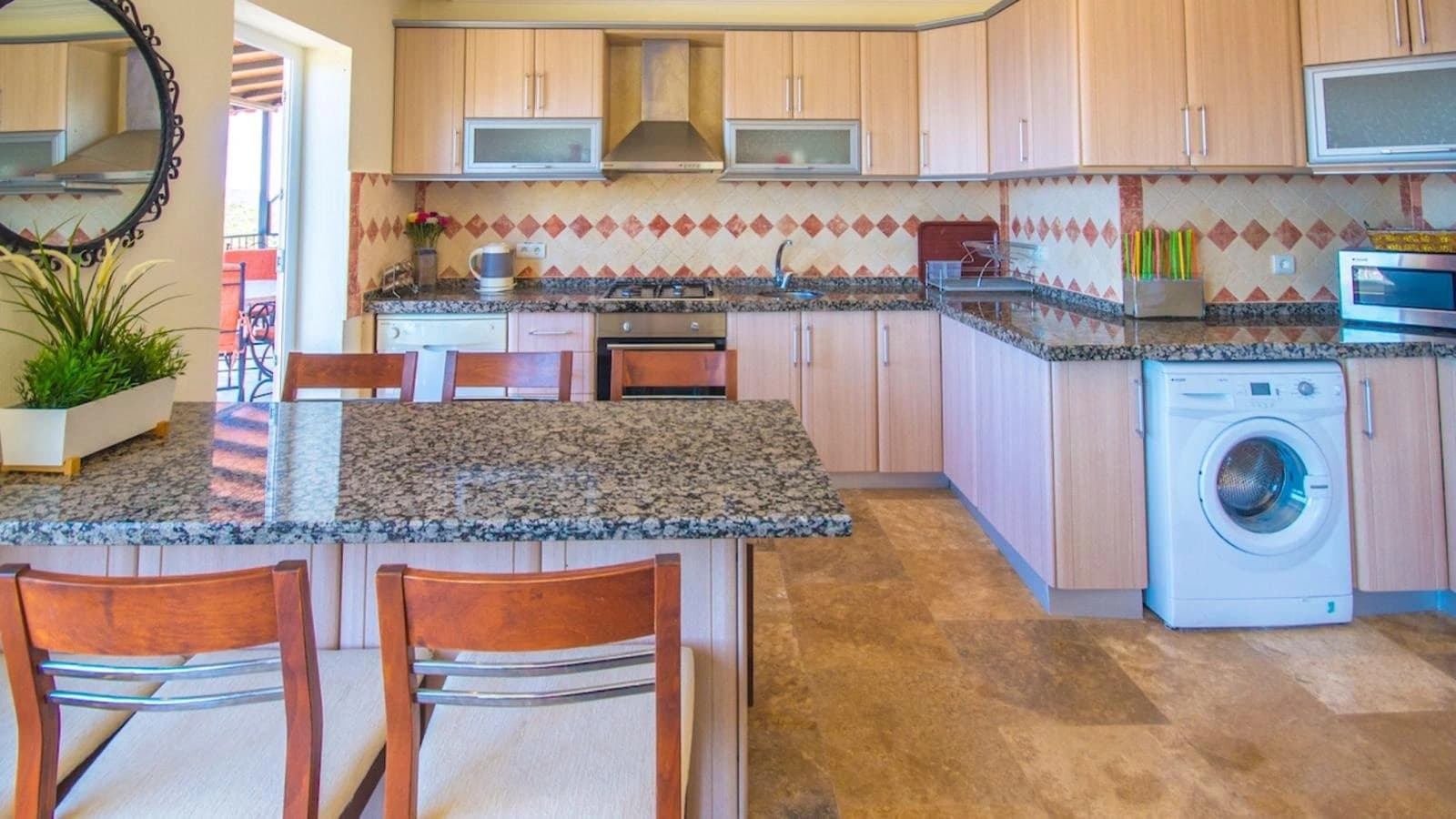 Spacious kitchen with modern appliances, granite counters, and integrated laundry.