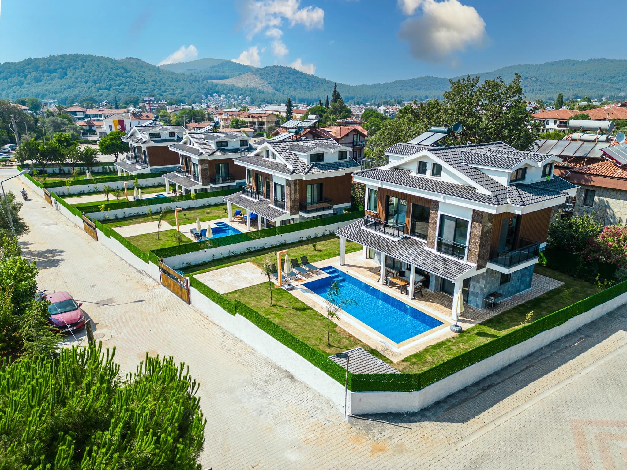 Ground-level perspective of the villa showing private pool area with manicured garden and mountain views.