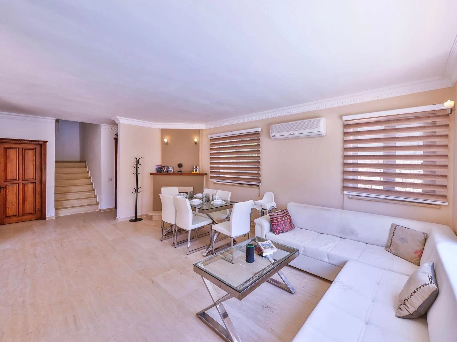 Contemporary living and dining area with comfortable sofa, dining table, and decorative fireplace.