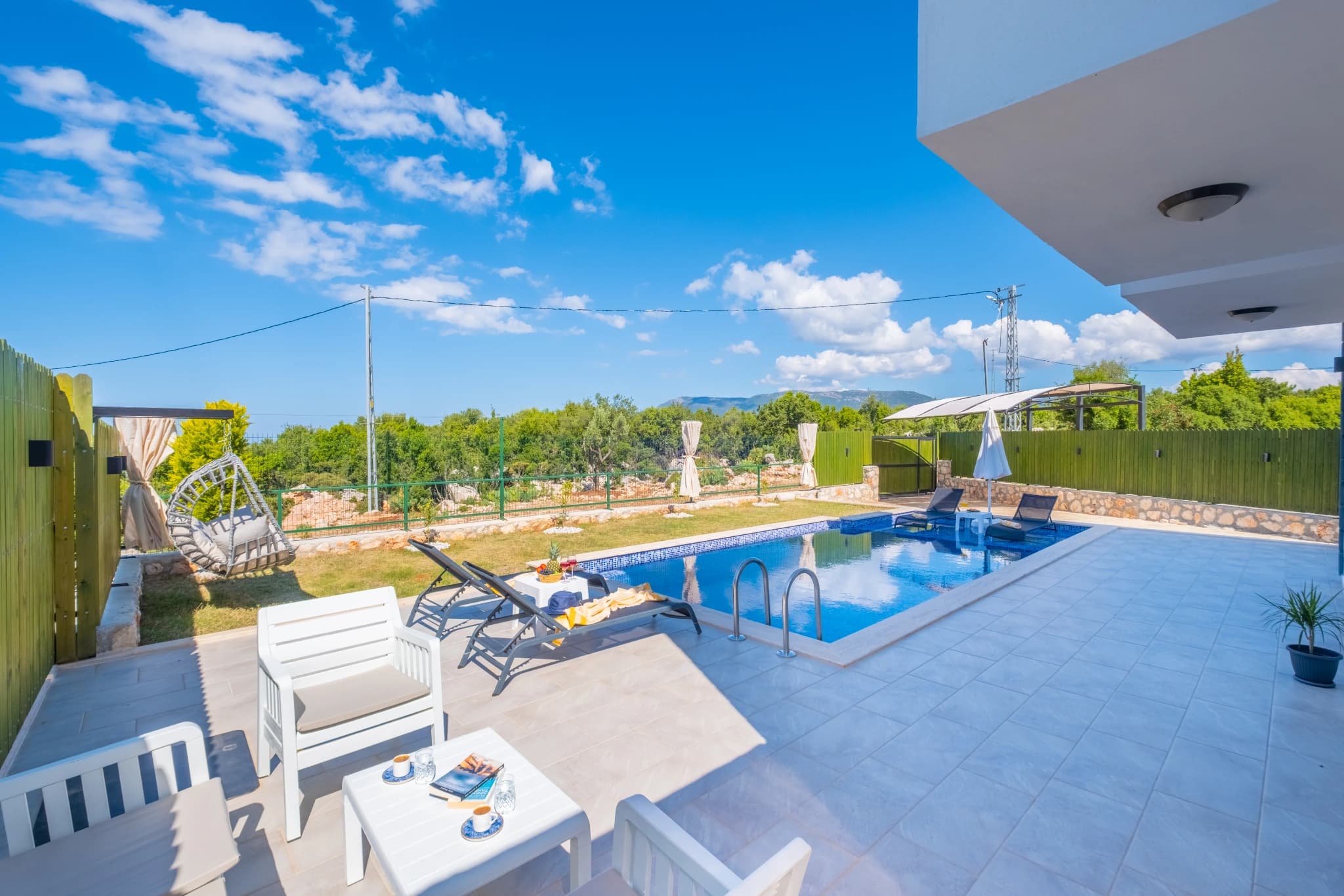 Pool area with lounge seating and distant mountain landscape.