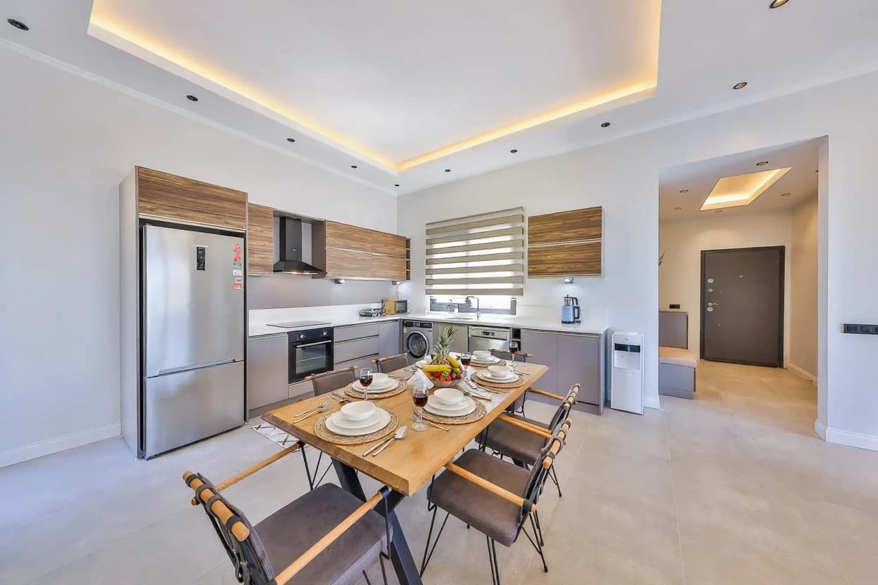 Contemporary kitchen with premium stainless steel appliances and adjacent dining area for six.