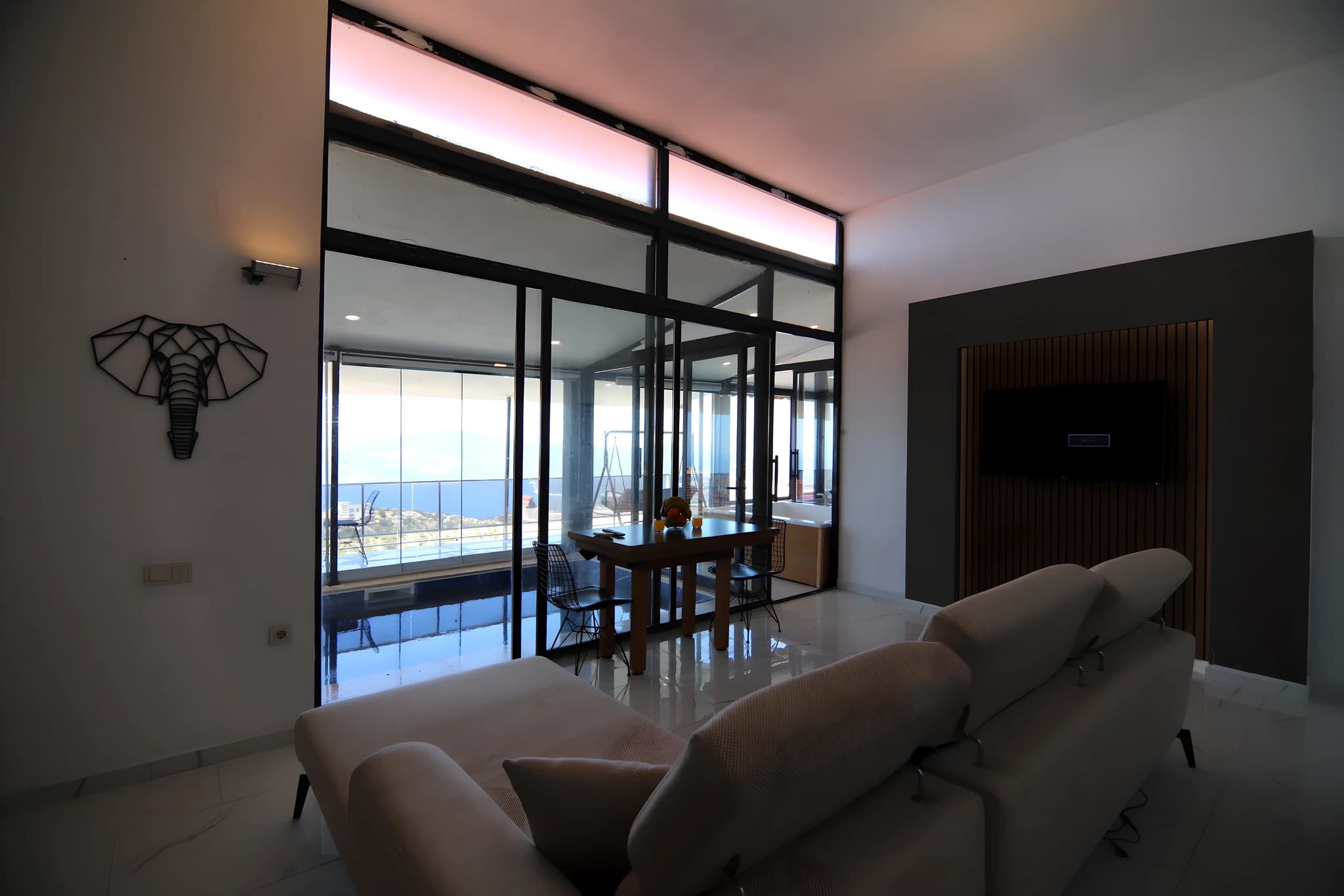 Modern living room with expansive sea views through floor-to-ceiling windows and contemporary seating.