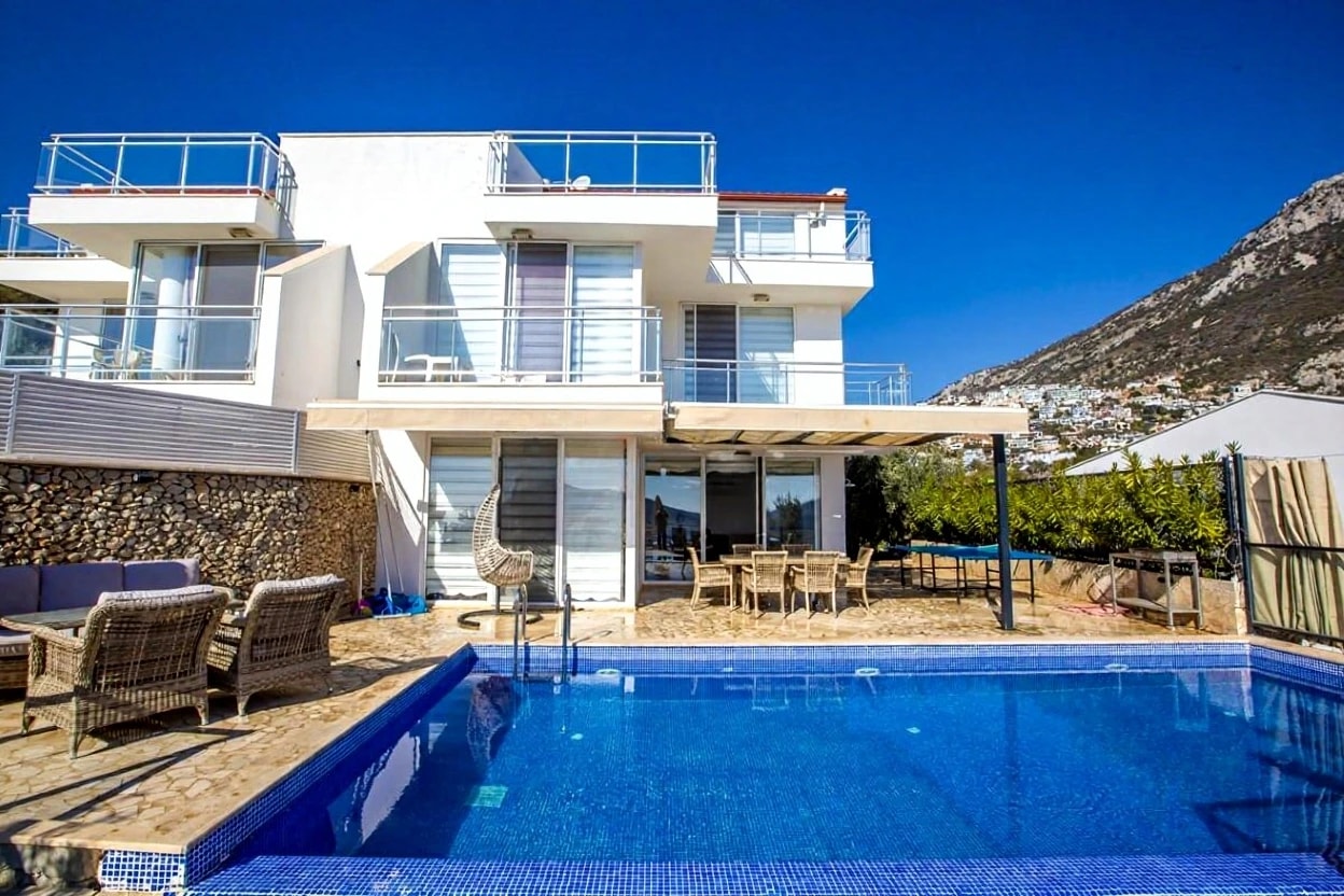 Stunning pool area with loungers overlooking the hillside and modern villa architecture.