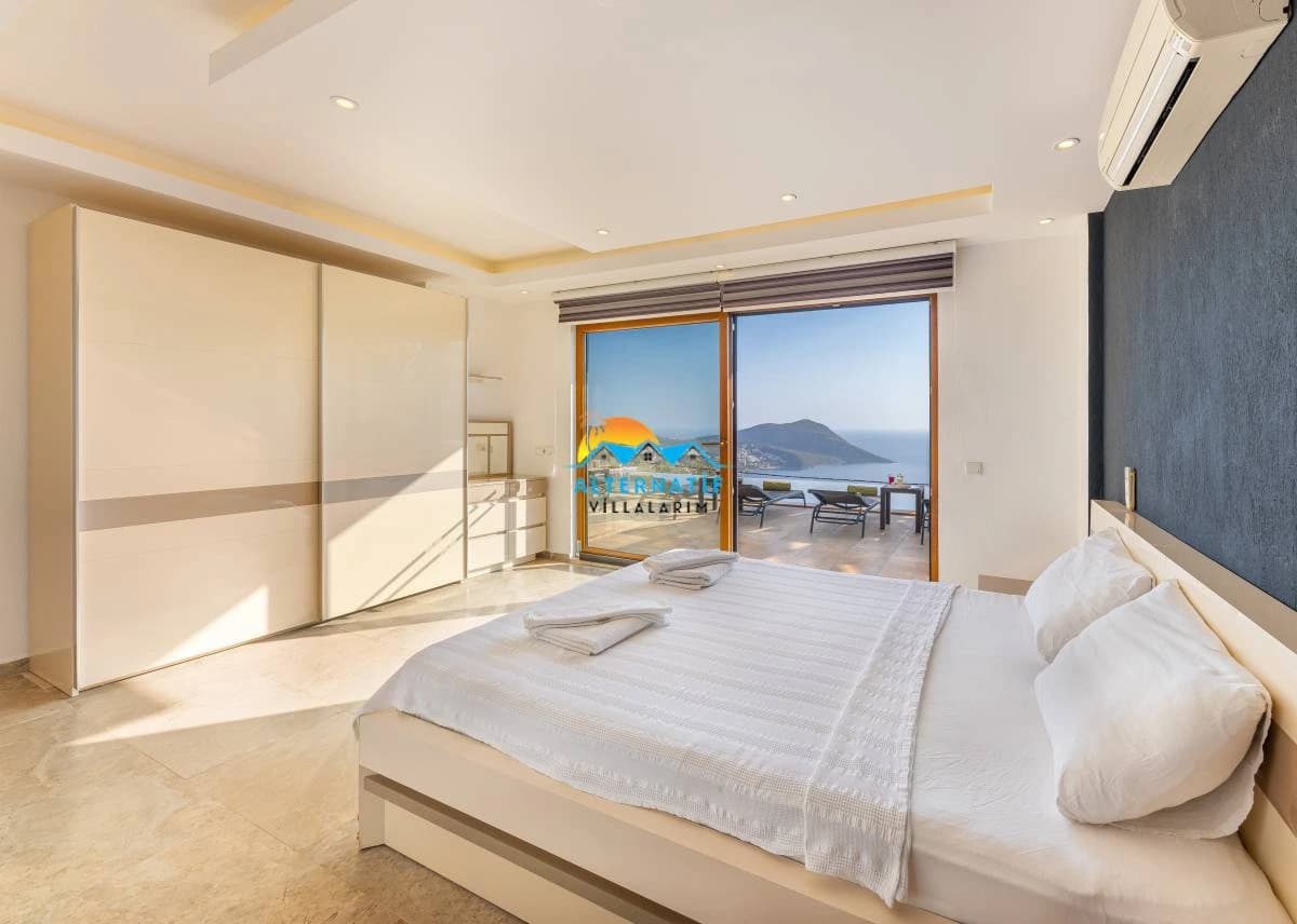 Spacious bedroom with a double bed, expansive sea view, built-in wardrobe, and access to private terrace.