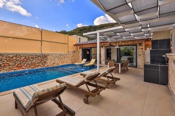Beautiful private pool with sun loungers and covered terrace area overlooking the garden.