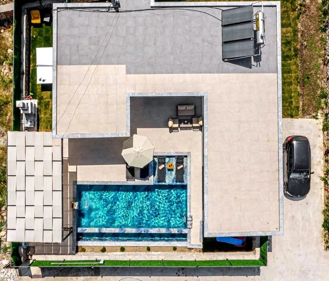 Aerial view of the villa with pool, terrace, and parking area.