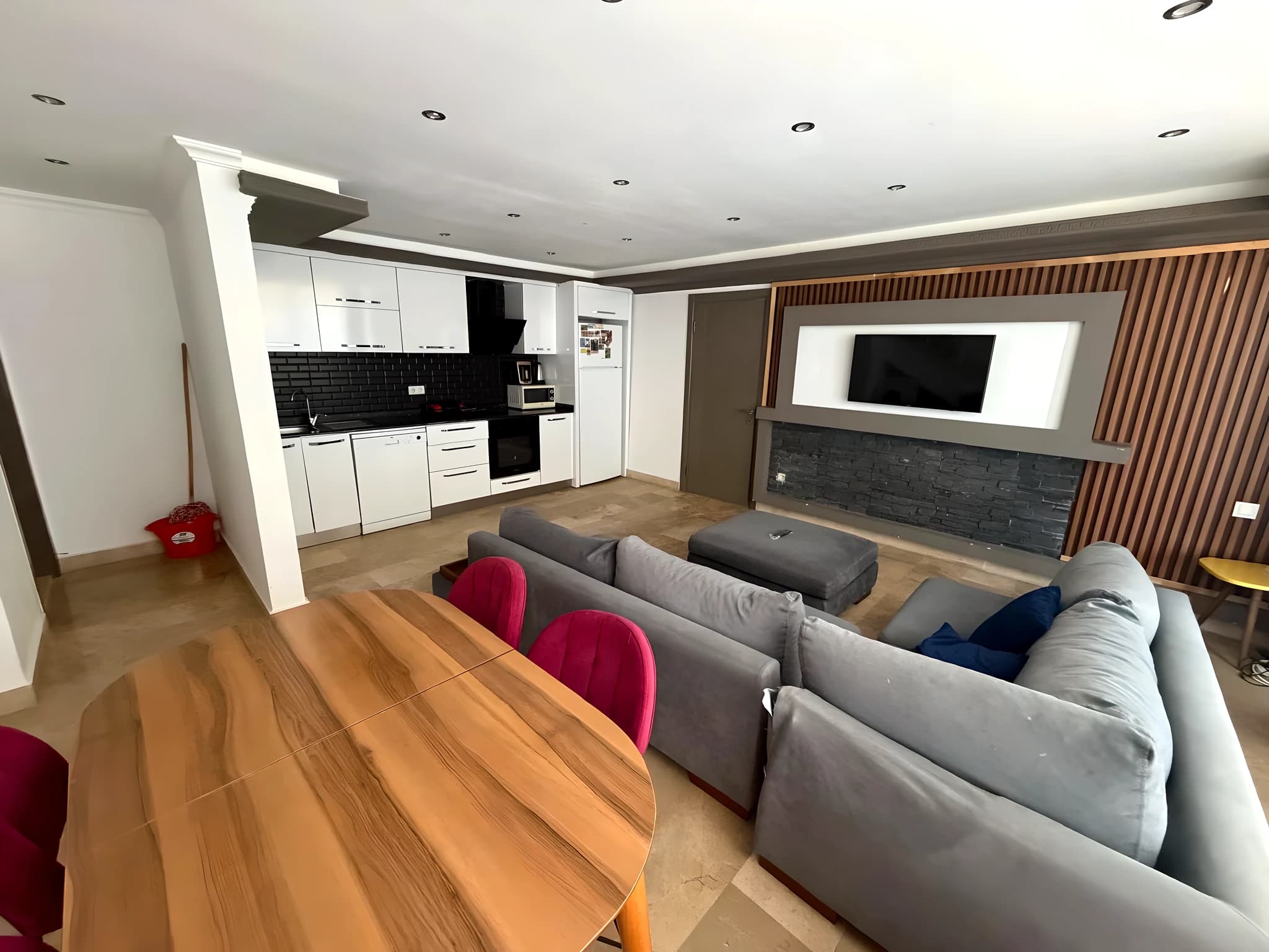 Spacious open-plan living and dining area with wood table and comfortable seating.