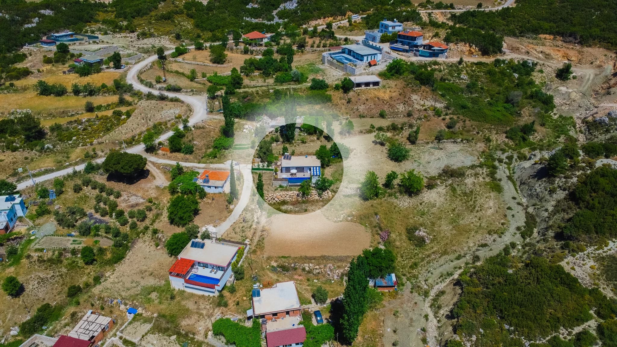 Wide aerial perspective showing the circular property layout and blue pool.