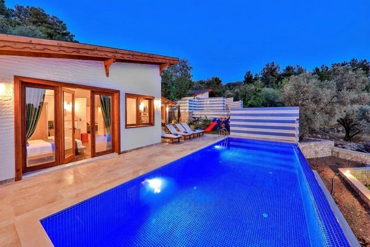 Kaş İslamlar'da Özel Havuzlu, Jakuzili ve Deniz Manzaralı 2 Yatak Odalı Korunaklı Villa – Modern private pool with lounge chairs and privacy fencing alongside the villa.