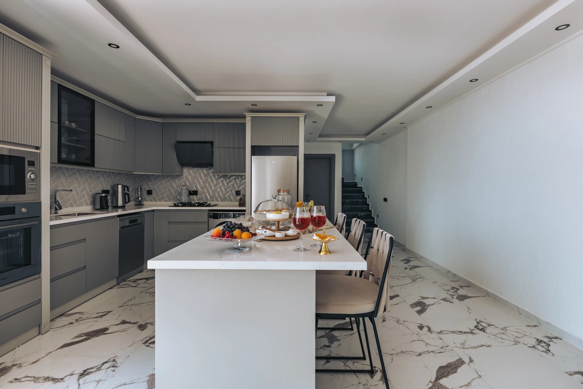 Modern kitchen with central island, integrated appliances, and adjacent dining space.