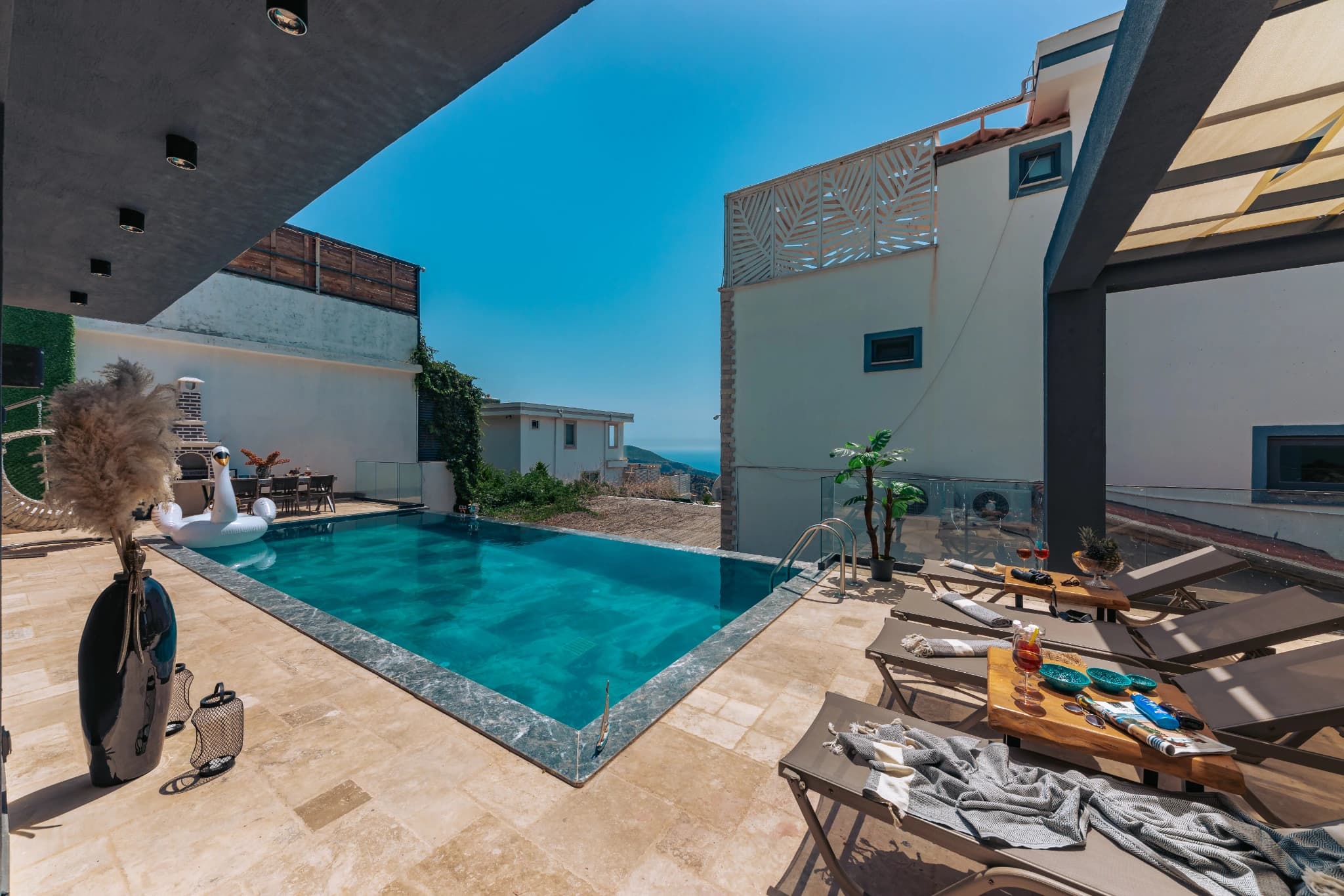 Pool area with comfortable sun lounging space and partial shade coverage.
