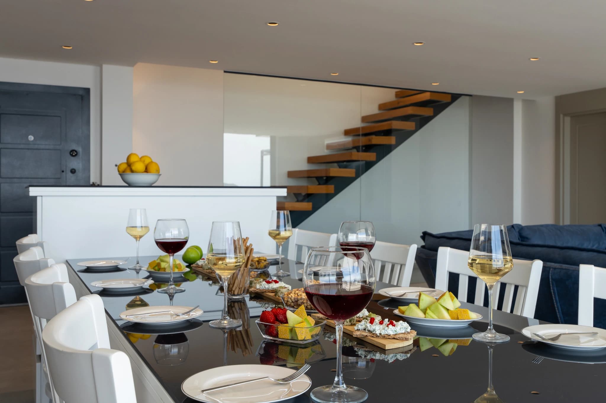 Elegant dining setup with wine service and modern staircase in the background.