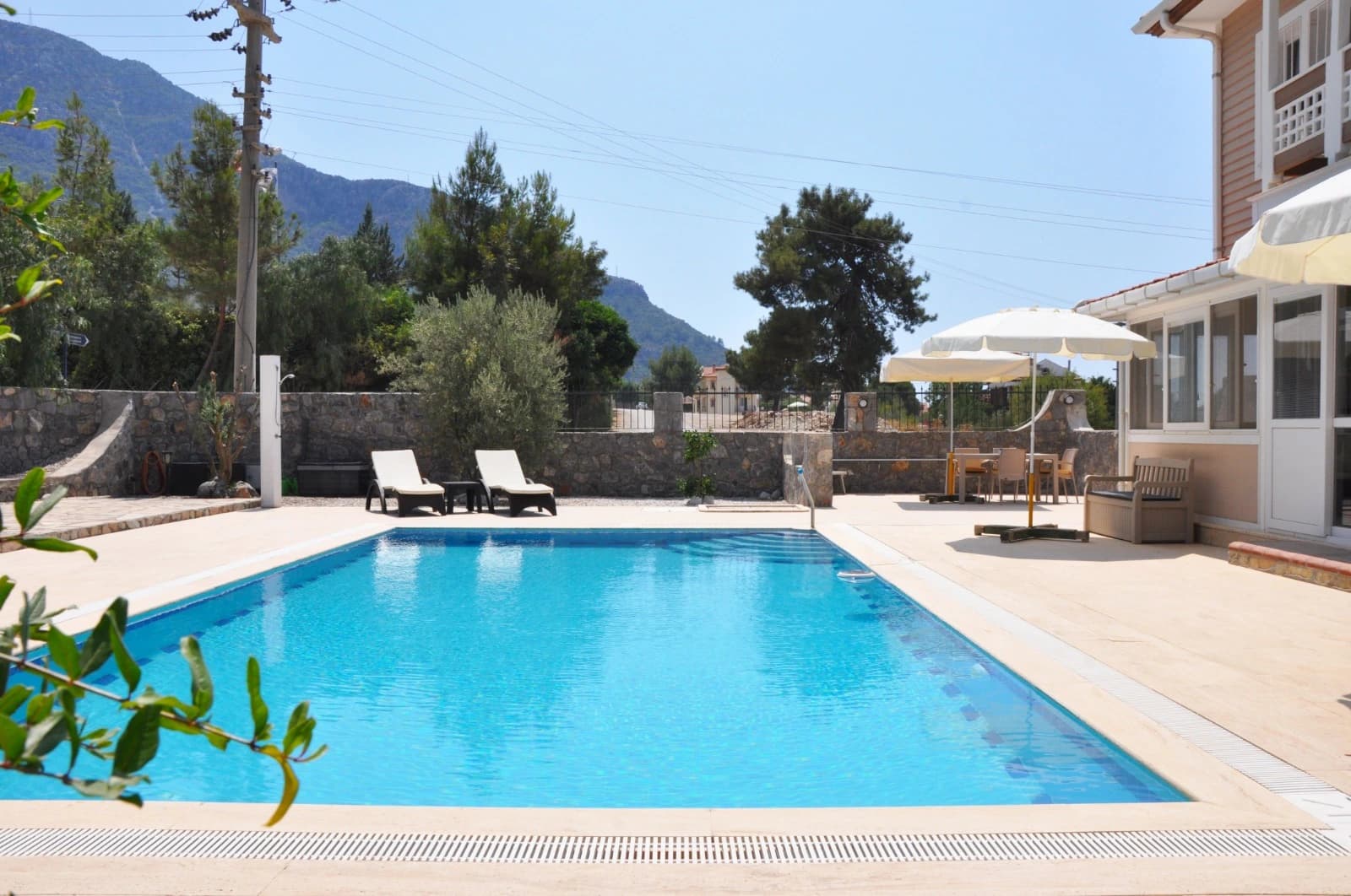 Rectangular private pool with mountain views and lounging area.
