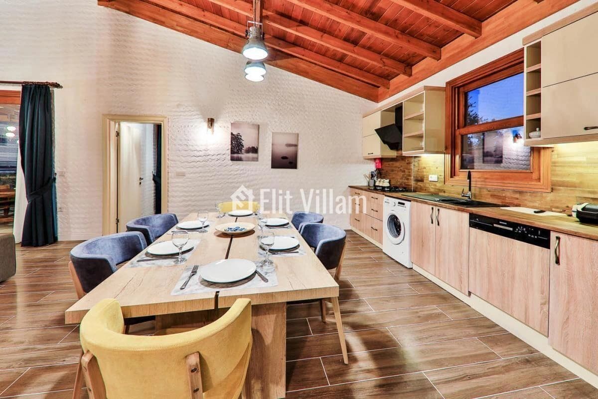 Spacious open-plan kitchen and dining area with wooden beams and modern appliances.