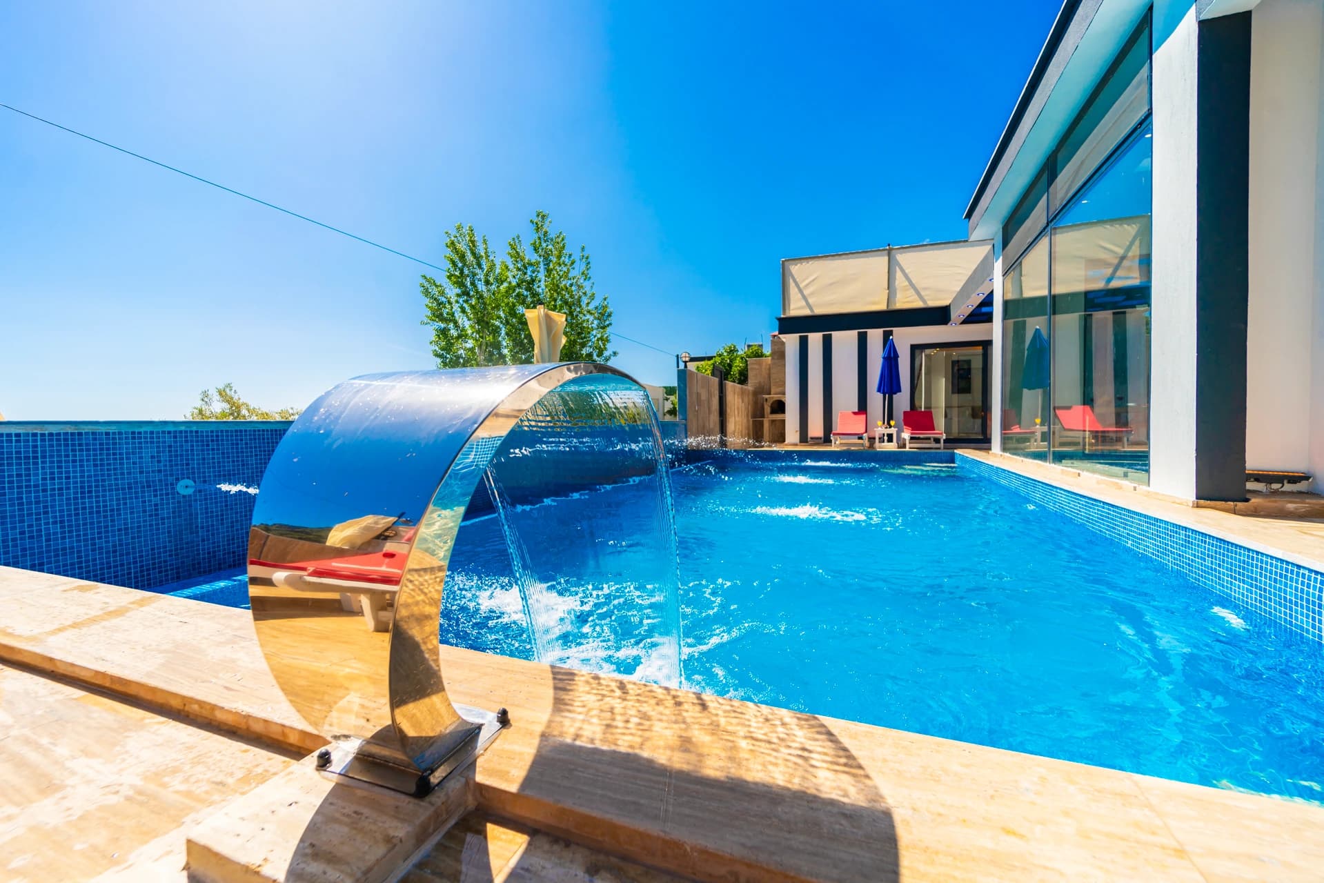 Pool with sculptural art installation and expansive timber deck.
