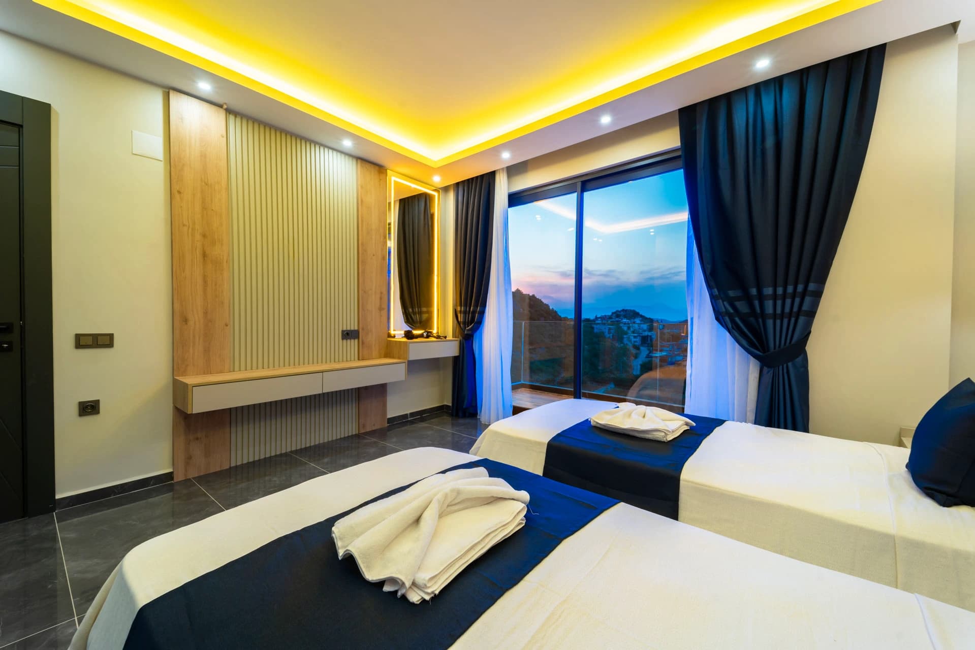 Spacious twin bedroom with panoramic mountain views and modern amenities.