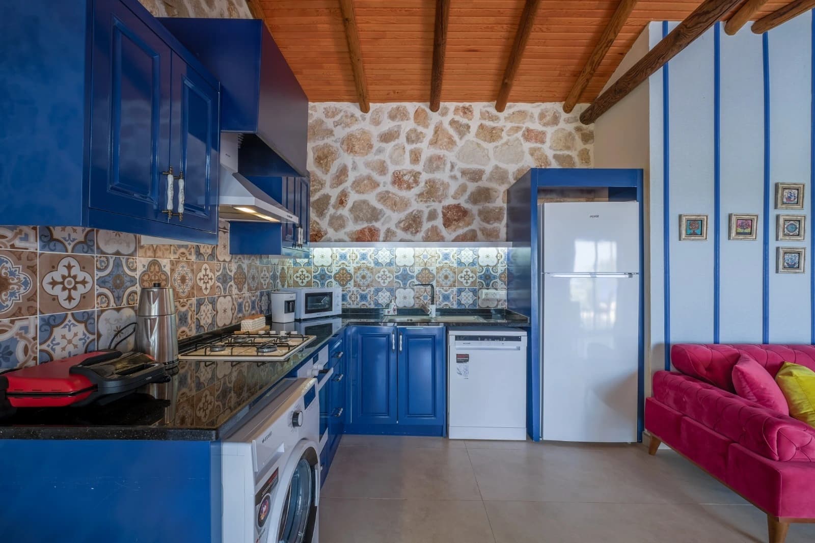 Modern kitchen corner featuring blue accents, patterned tiles, and stone architecture.