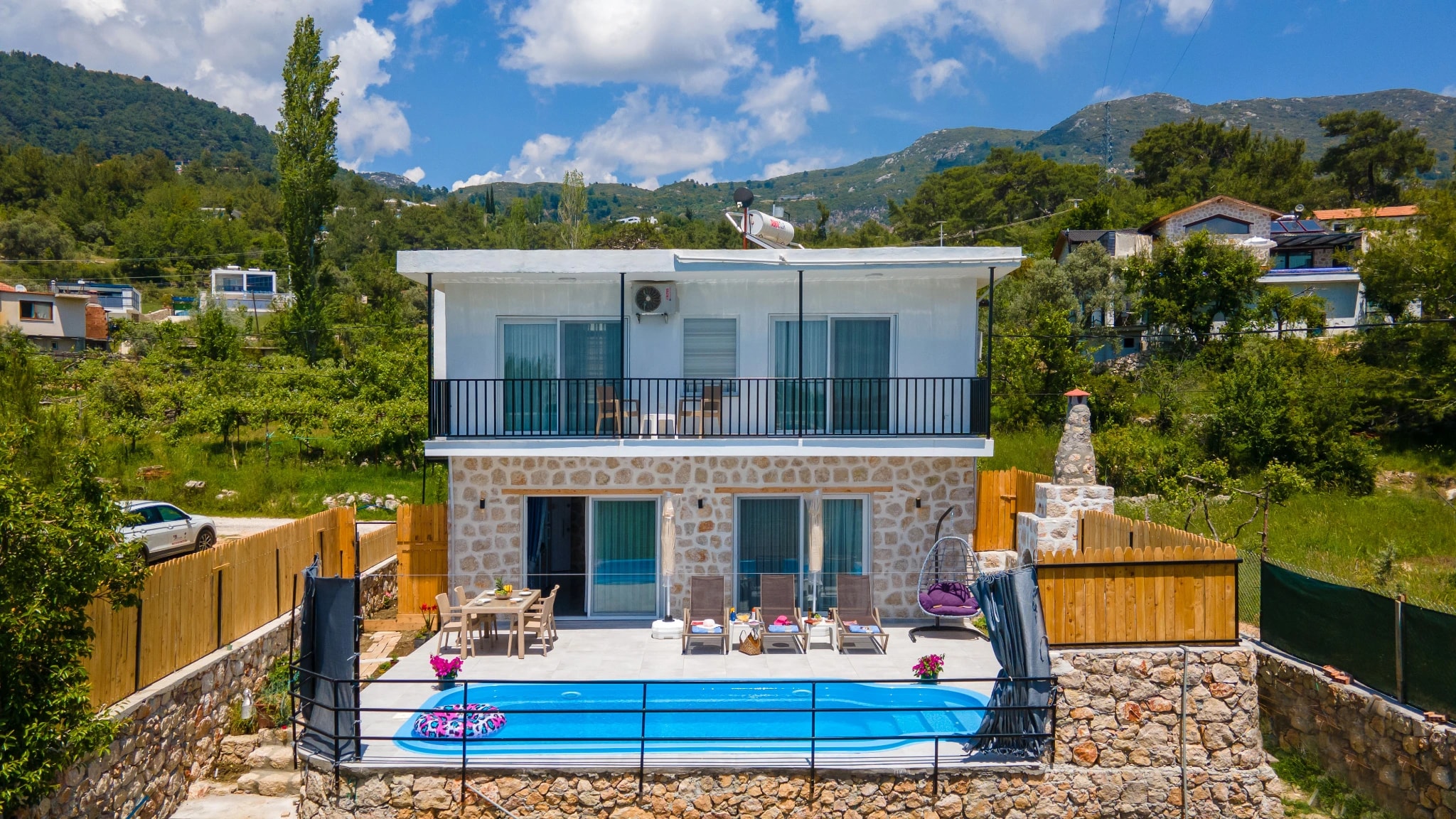 Modern two-story villa with private pool and mountain views set in lush landscape.