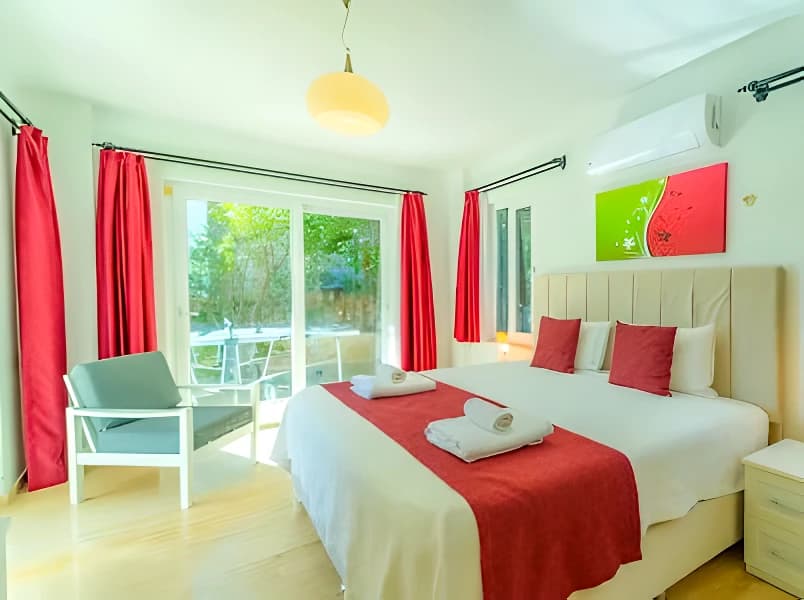 Bright bedroom with twin beds, balcony access, and garden views.