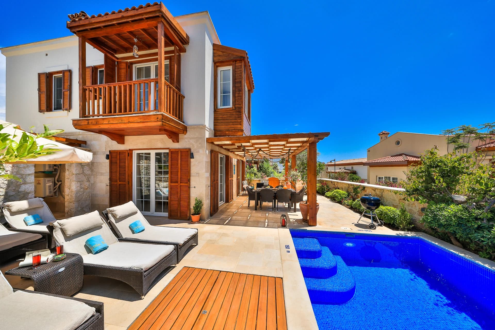 Private pool with adjacent sun loungers and mountain views from the villa.