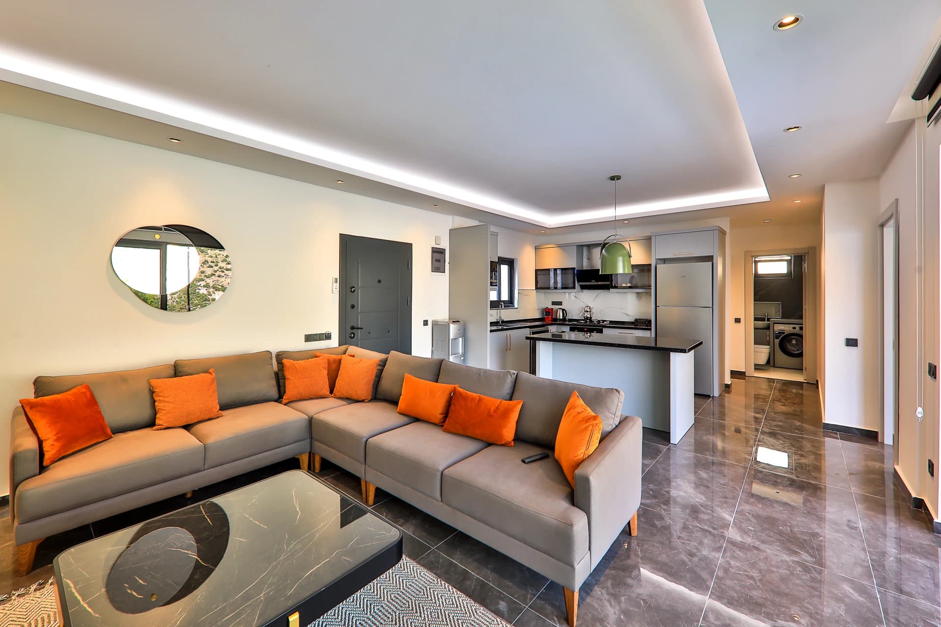 Light-filled open-plan space connecting living area with kitchen and laundry facilities.