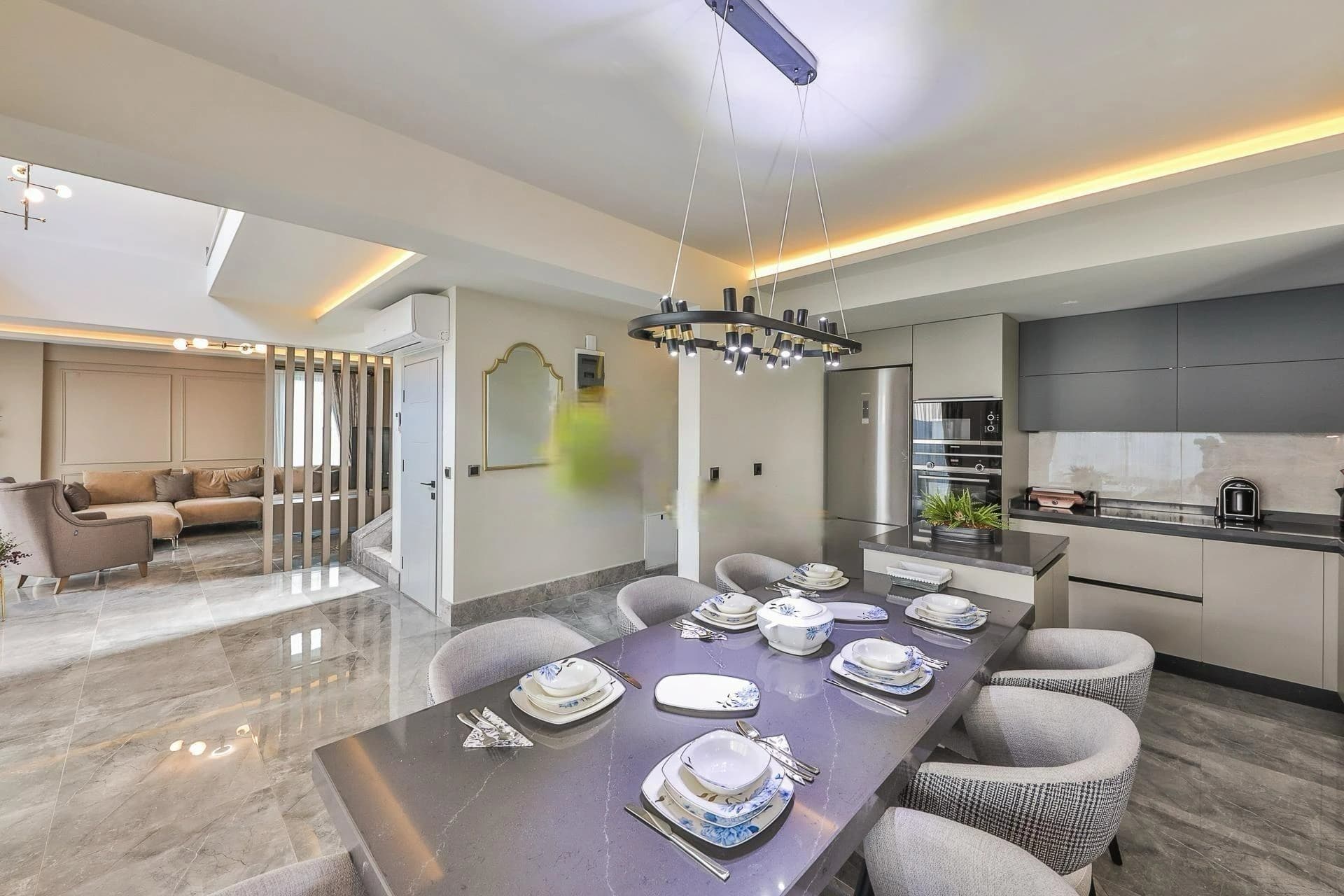 Modern open-plan dining and kitchen area with premium finishes and ambient lighting.