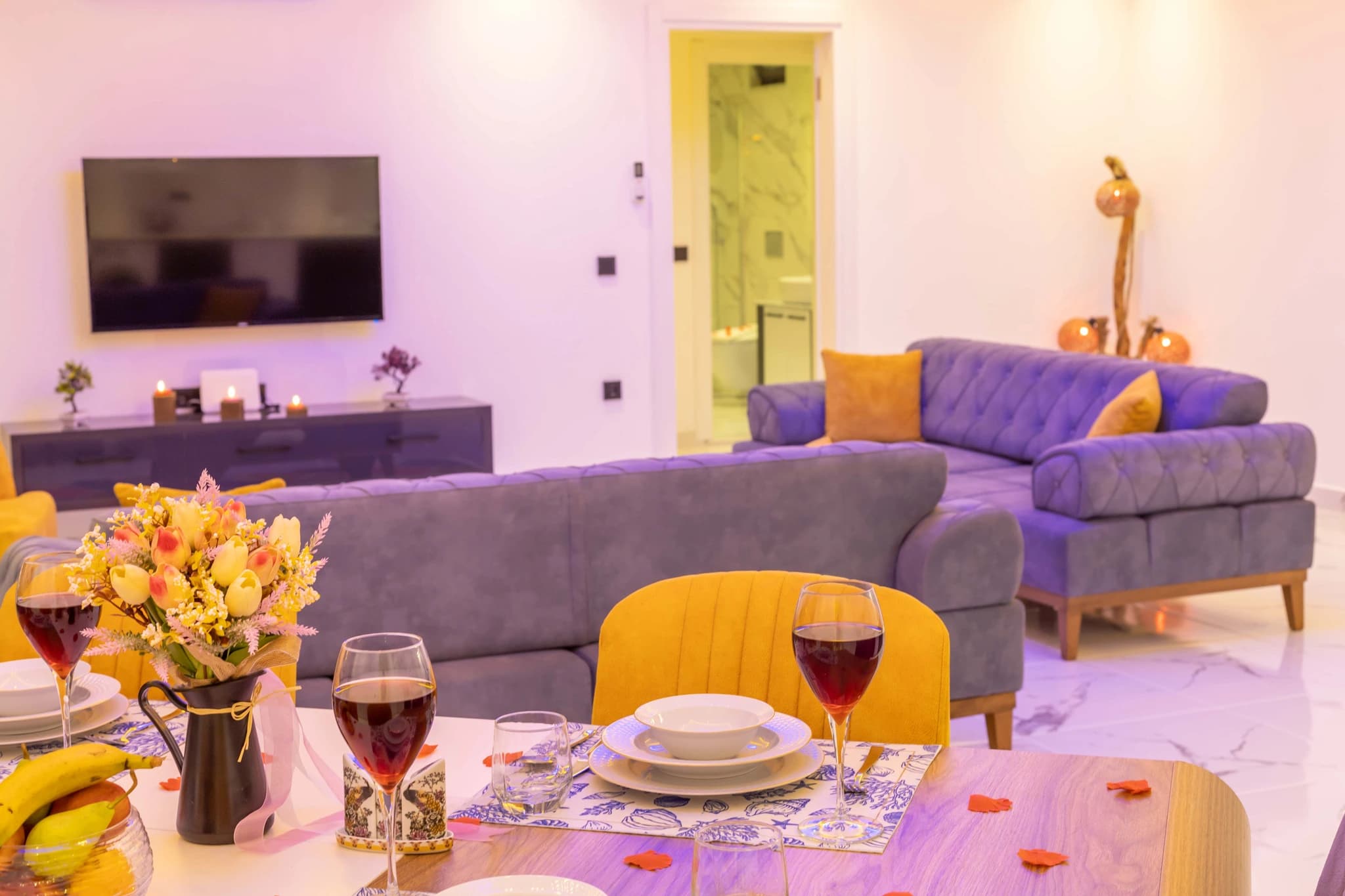 Kalkan'da Doğa Manzaralı, Özel Havuzlu ve Korunaklı Bahçeli Villa – Open-plan living and dining space with modern sofas, TV, and elegant décor.