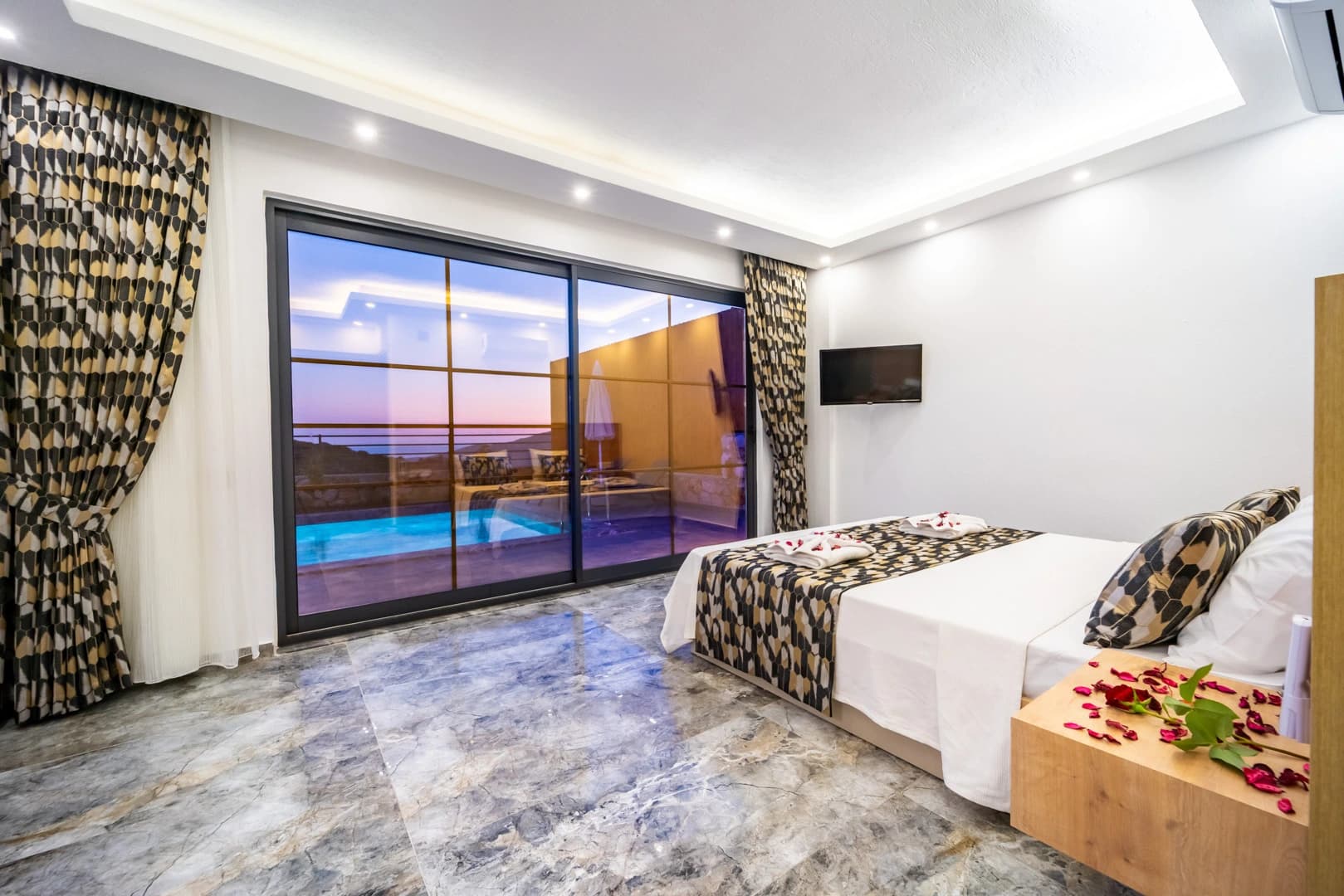 Spacious bedroom with twin beds and panoramic pool and sea views.