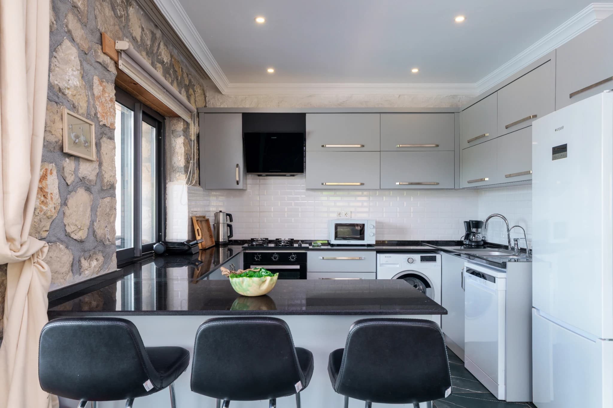 Modern kitchen with gas cooking, island counter, and integrated appliances.