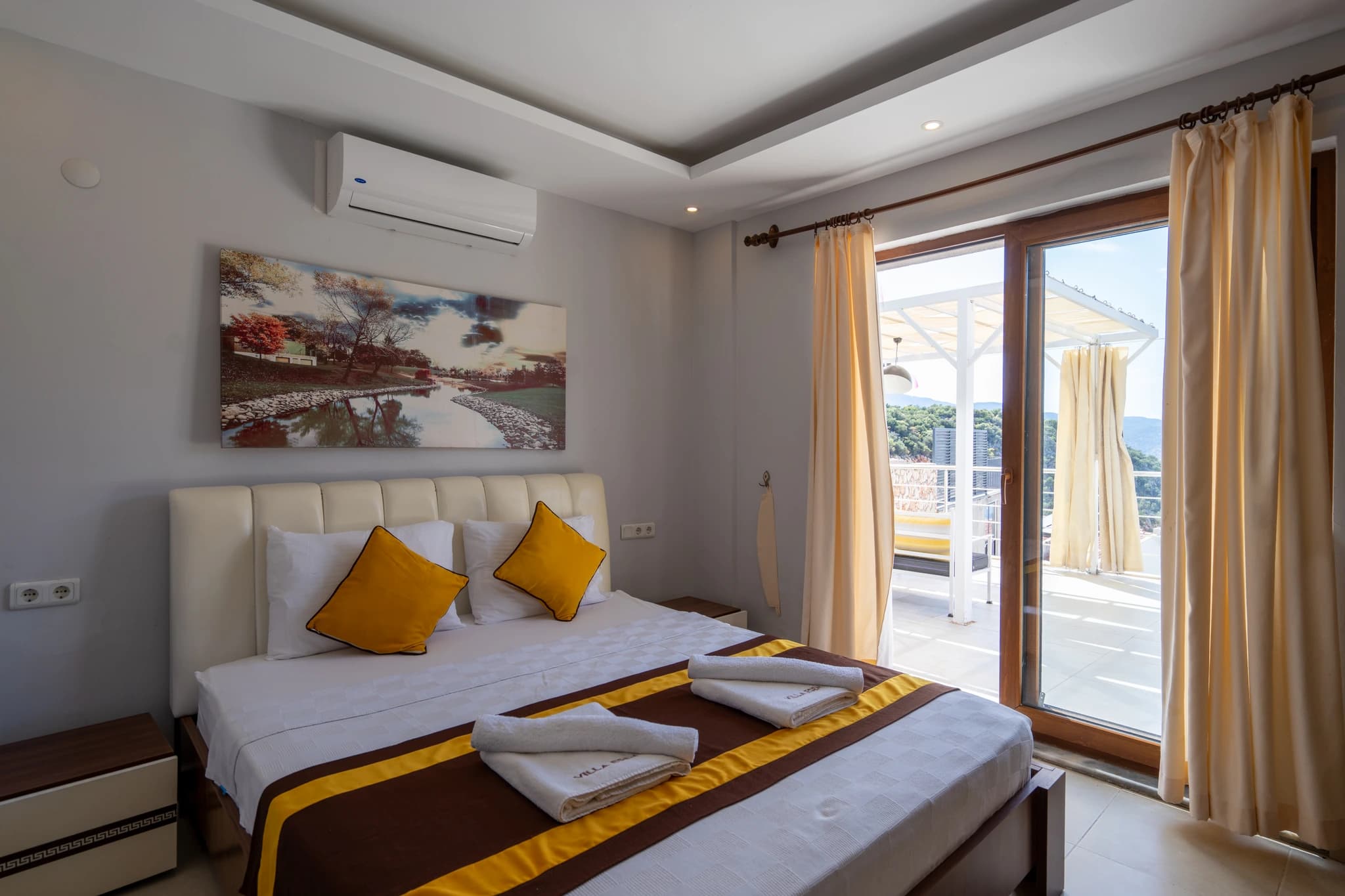 Bright bedroom with double bed, ocean views, and access to a private terrace.