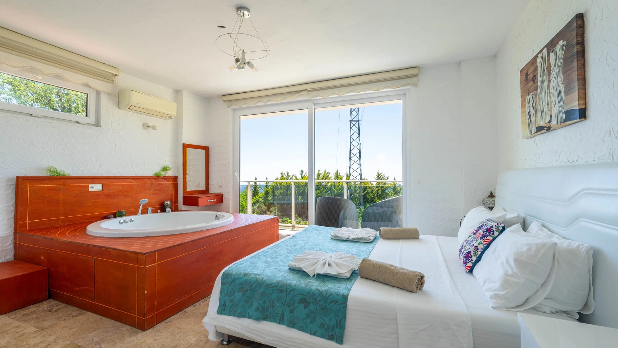 Master bedroom with in-room jacuzzi tub and private balcony overlooking gardens.