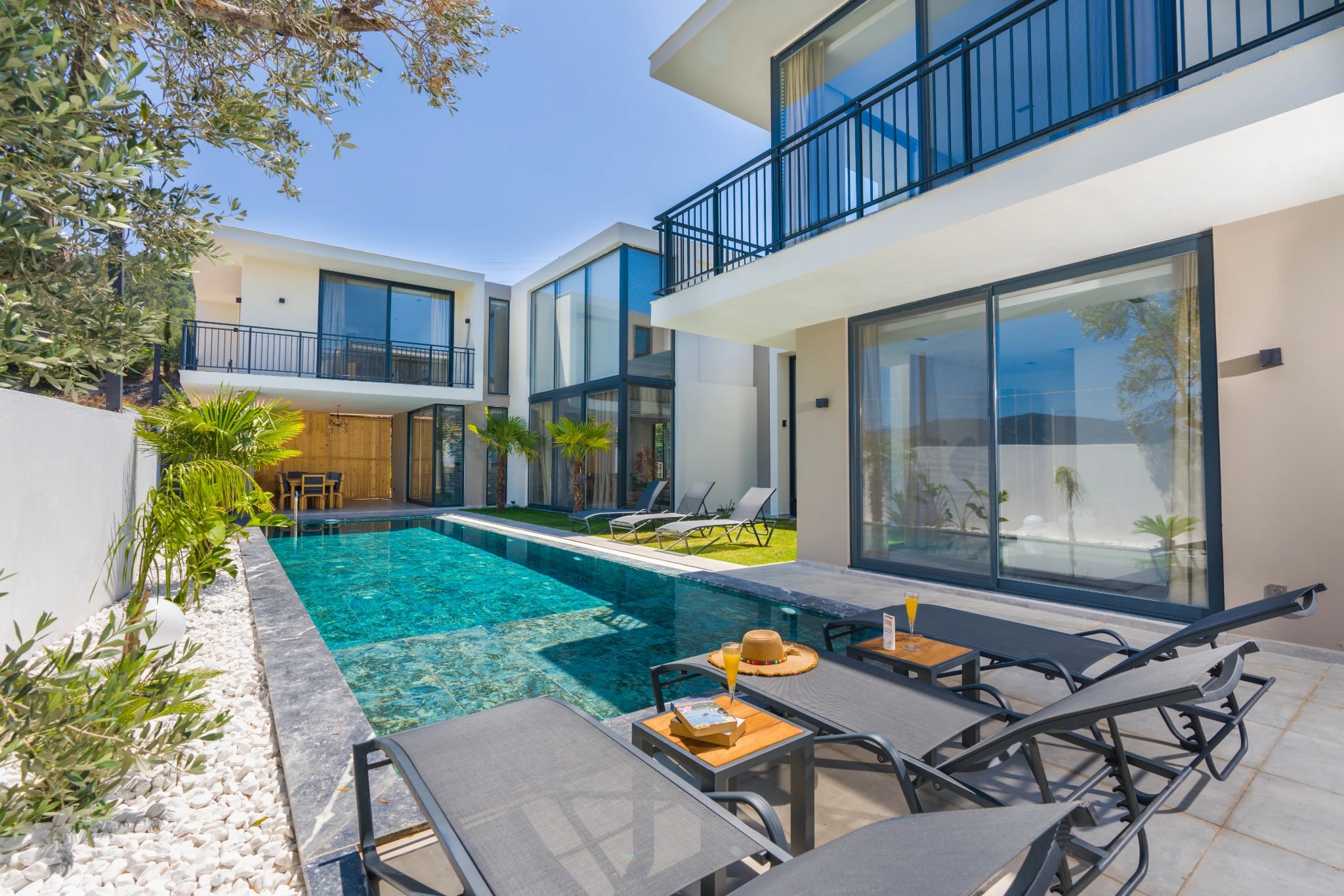Stunning private pool with sun loungers and modern villa architecture.