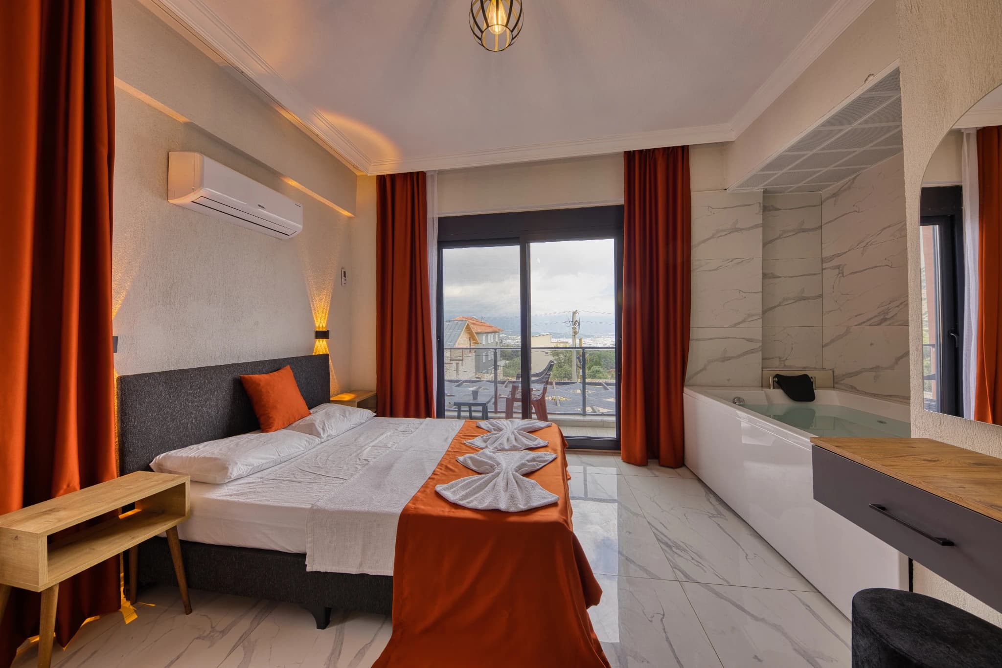 Spacious bedroom featuring queen bed, balcony with sea views, and modern ensuite bathroom.