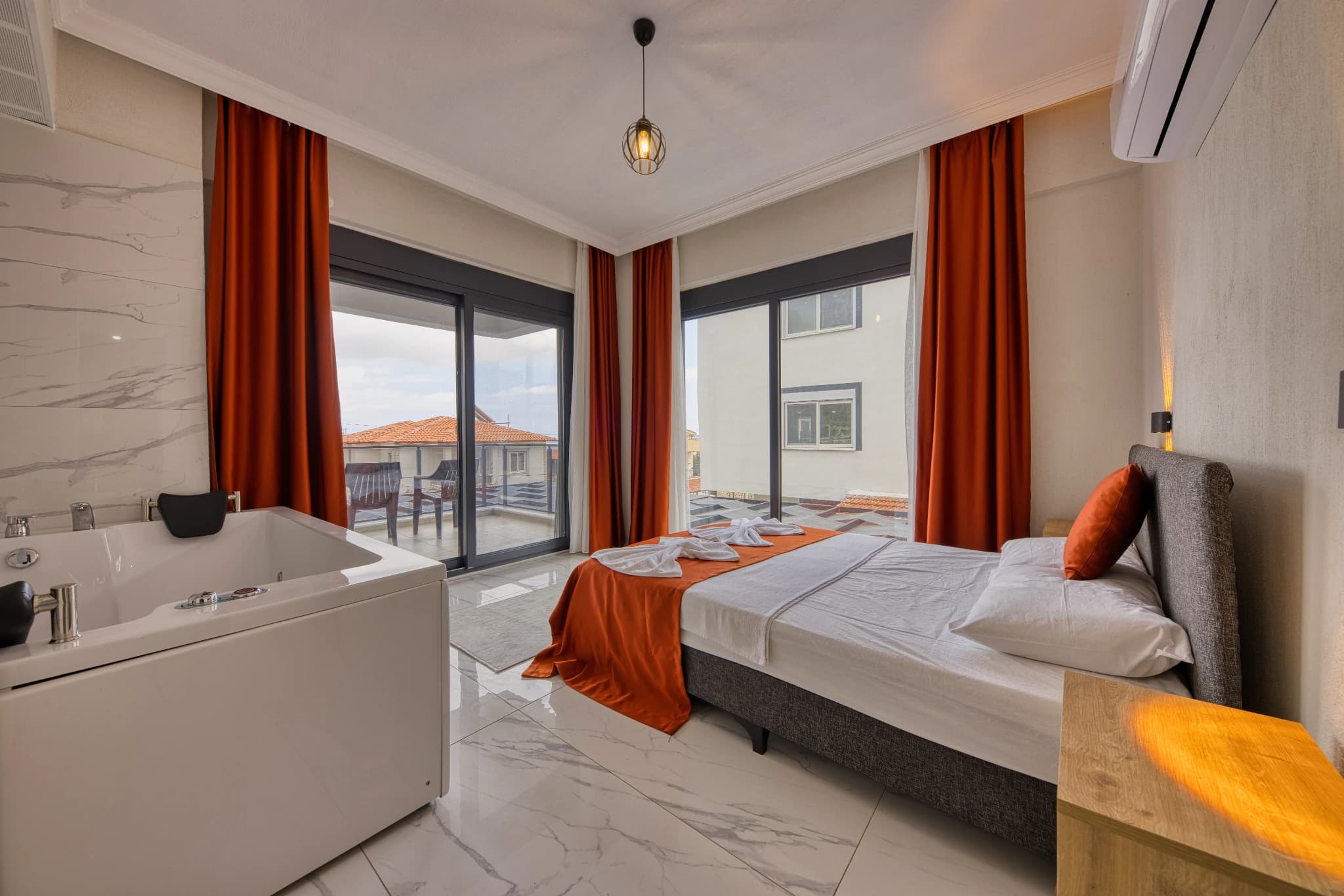 Spacious bedroom with in-room jacuzzi and private balcony access.