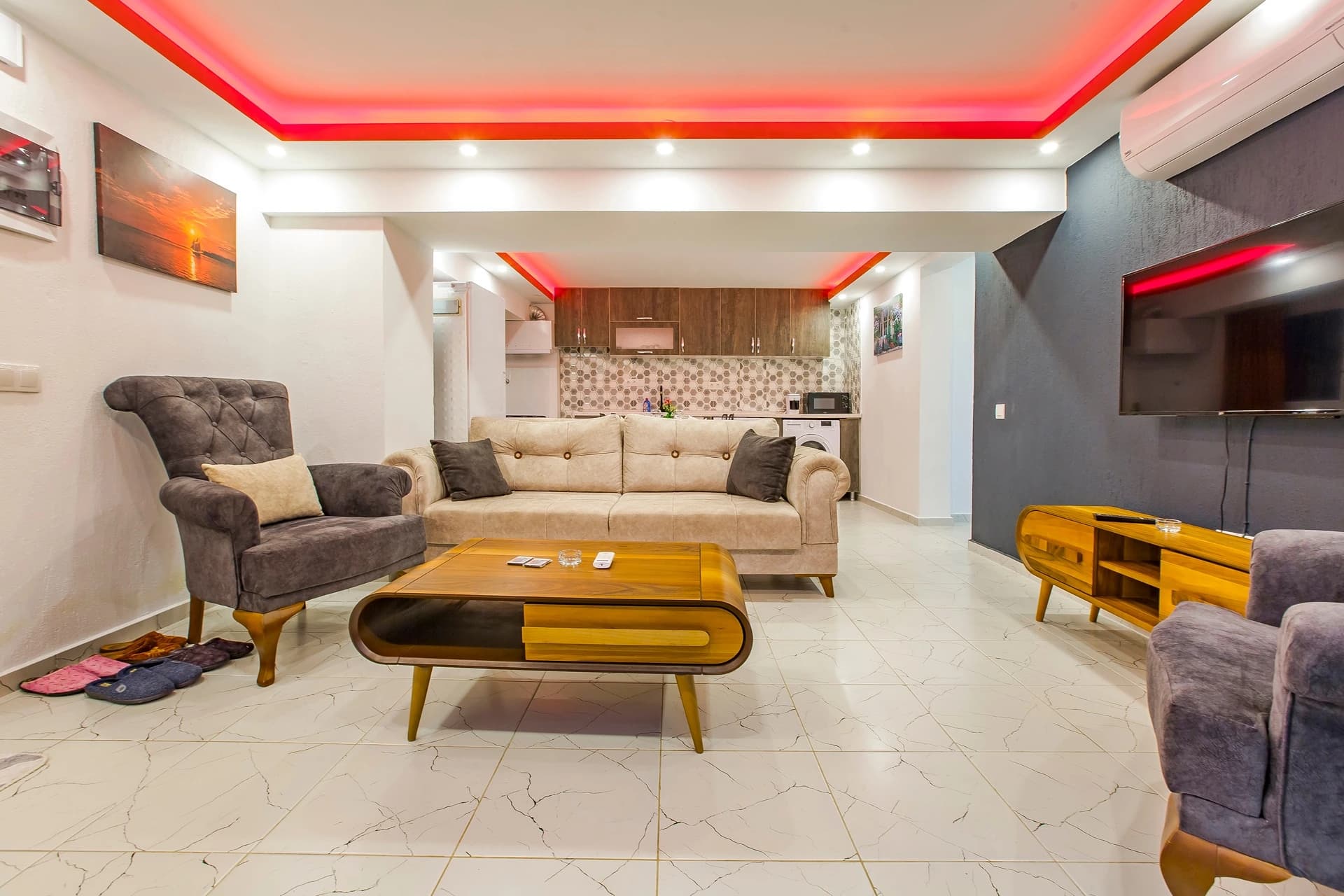 Kalkan Yakınlarında Orman İçinde Korunaklı, Özel Havuzlu ve Jakuzili Villa – Open-plan living room with sofa seating, integrated kitchenette, and striking red accent ceiling.