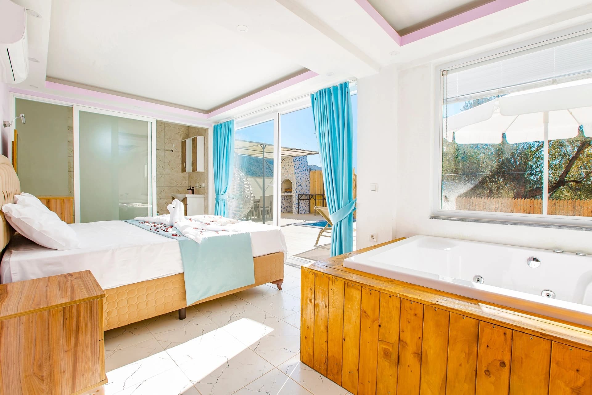 Kalkan Yakınlarında Orman İçinde Korunaklı, Özel Havuzlu ve Jakuzili Villa – Luxurious master bedroom with integrated jacuzzi, nature views, and direct terrace access.