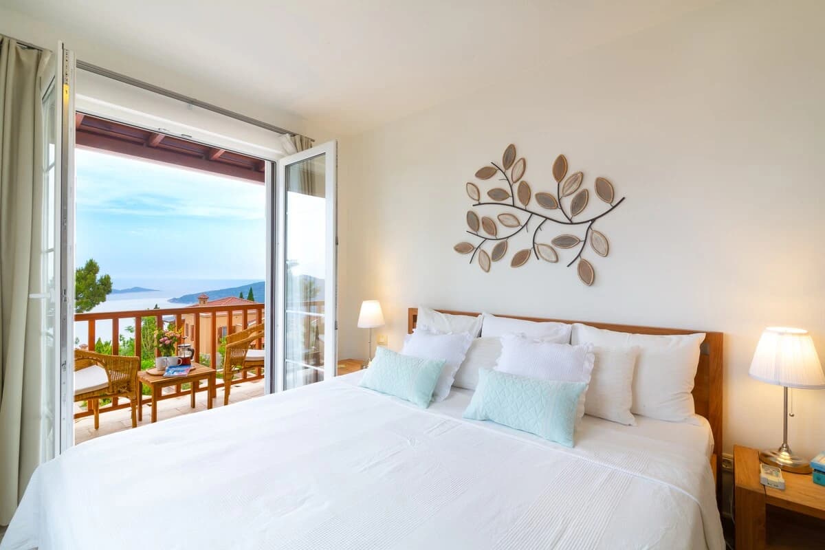 Bedroom with king bed, access to sea-view balcony, and modern amenities.