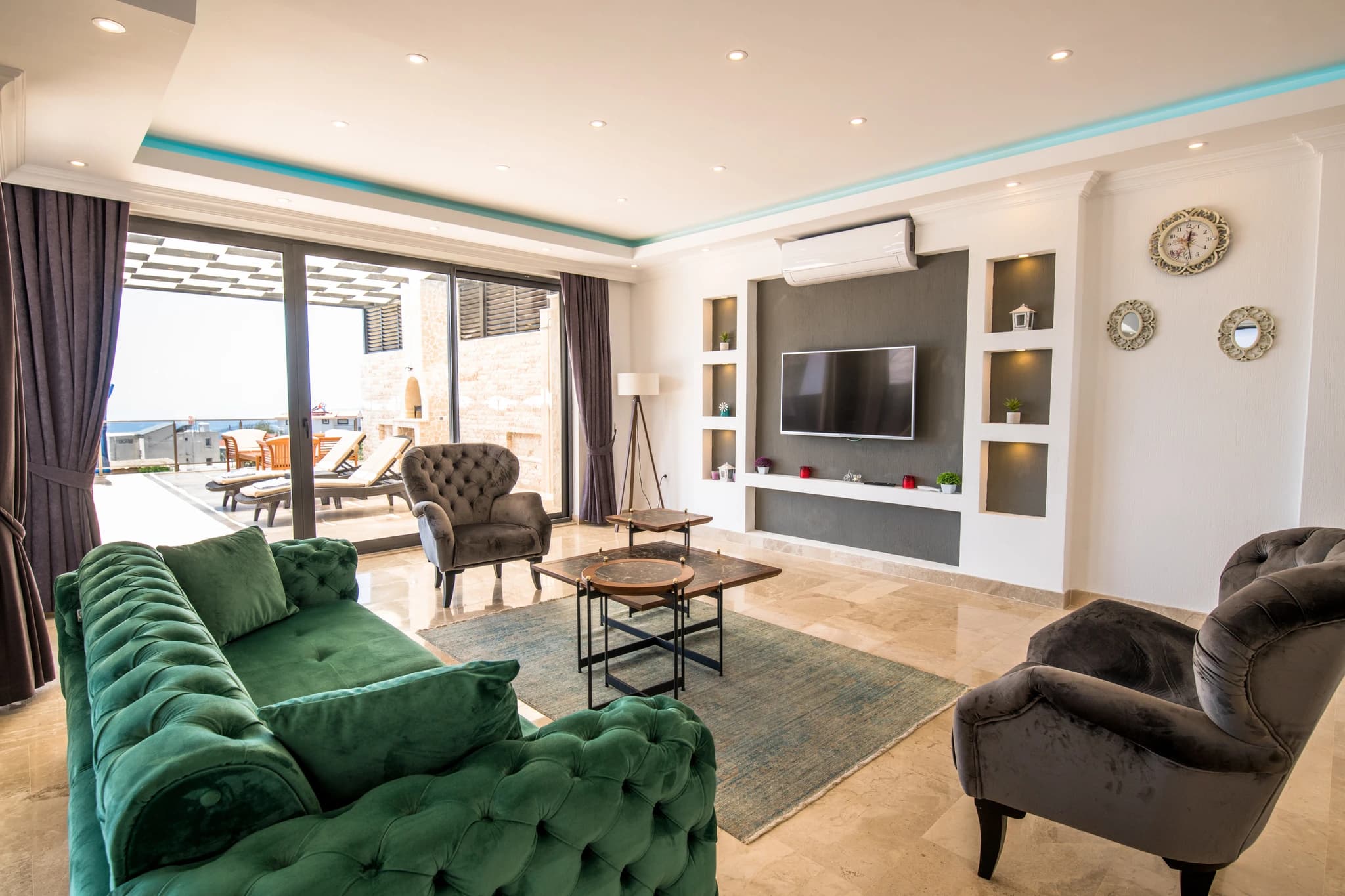 Kalkan'da Deniz Manzaralı, İç ve Dış Havuzlu Korunaklı Balayı Villası – Contemporary living room with velvet seating, flat-screen TV, and direct terrace access.