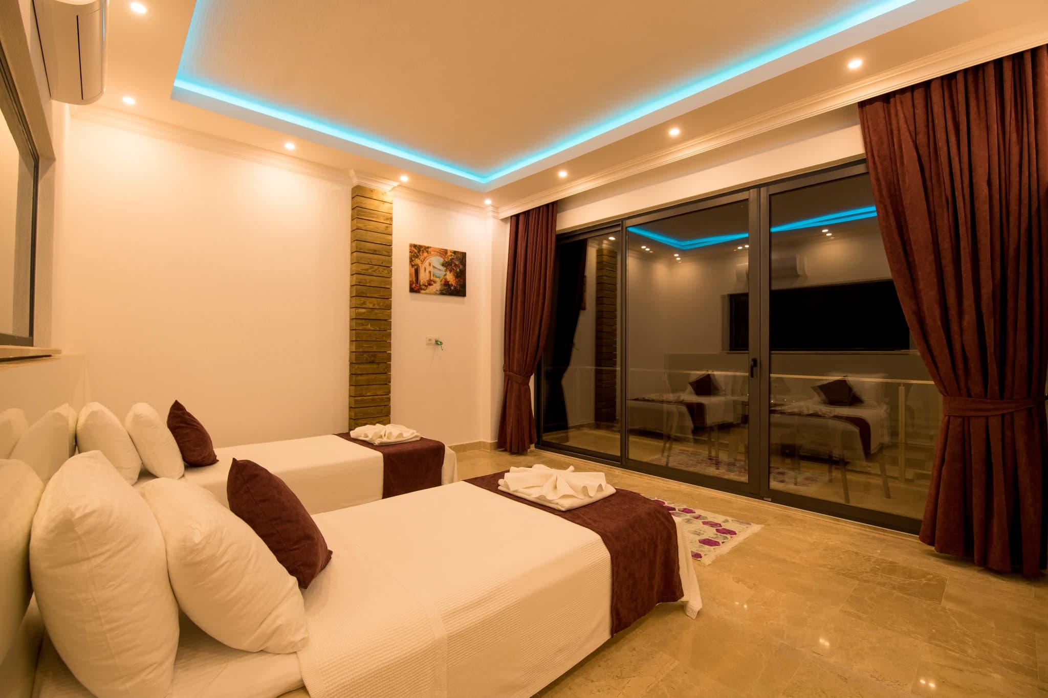 Kalkan'da Deniz Manzaralı, İç ve Dış Havuzlu Korunaklı Balayı Villası – Spacious master bedroom with twin beds and elegant contemporary styling.