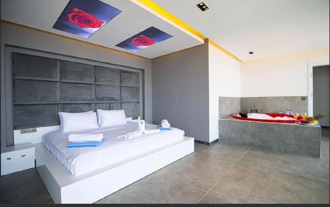 Luxurious master bedroom with king bed and integrated ensuite bathtub.