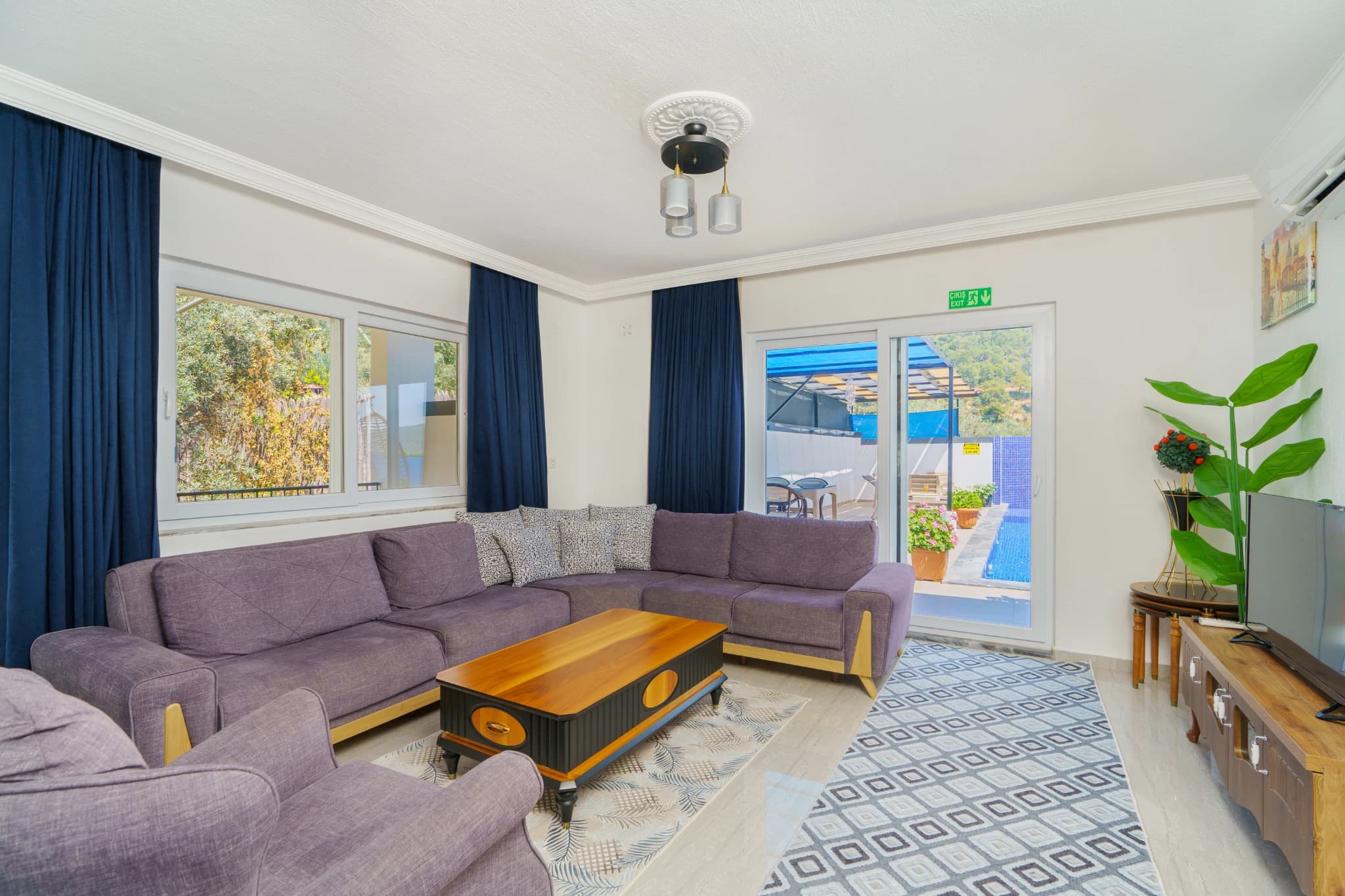 Spacious living room with large sectional seating, tv, and access to garden terrace.