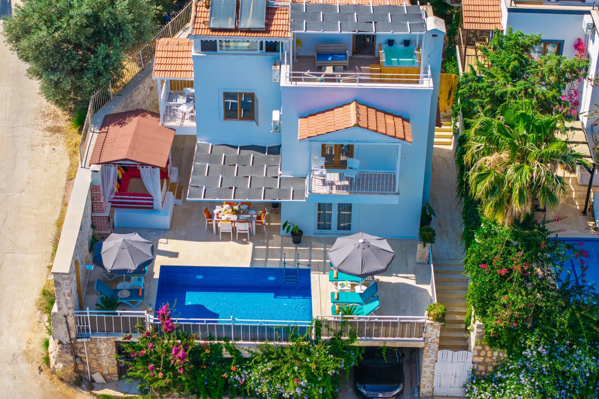 Close-up aerial of the sparkling pool area with comfortable lounging and dining spaces.