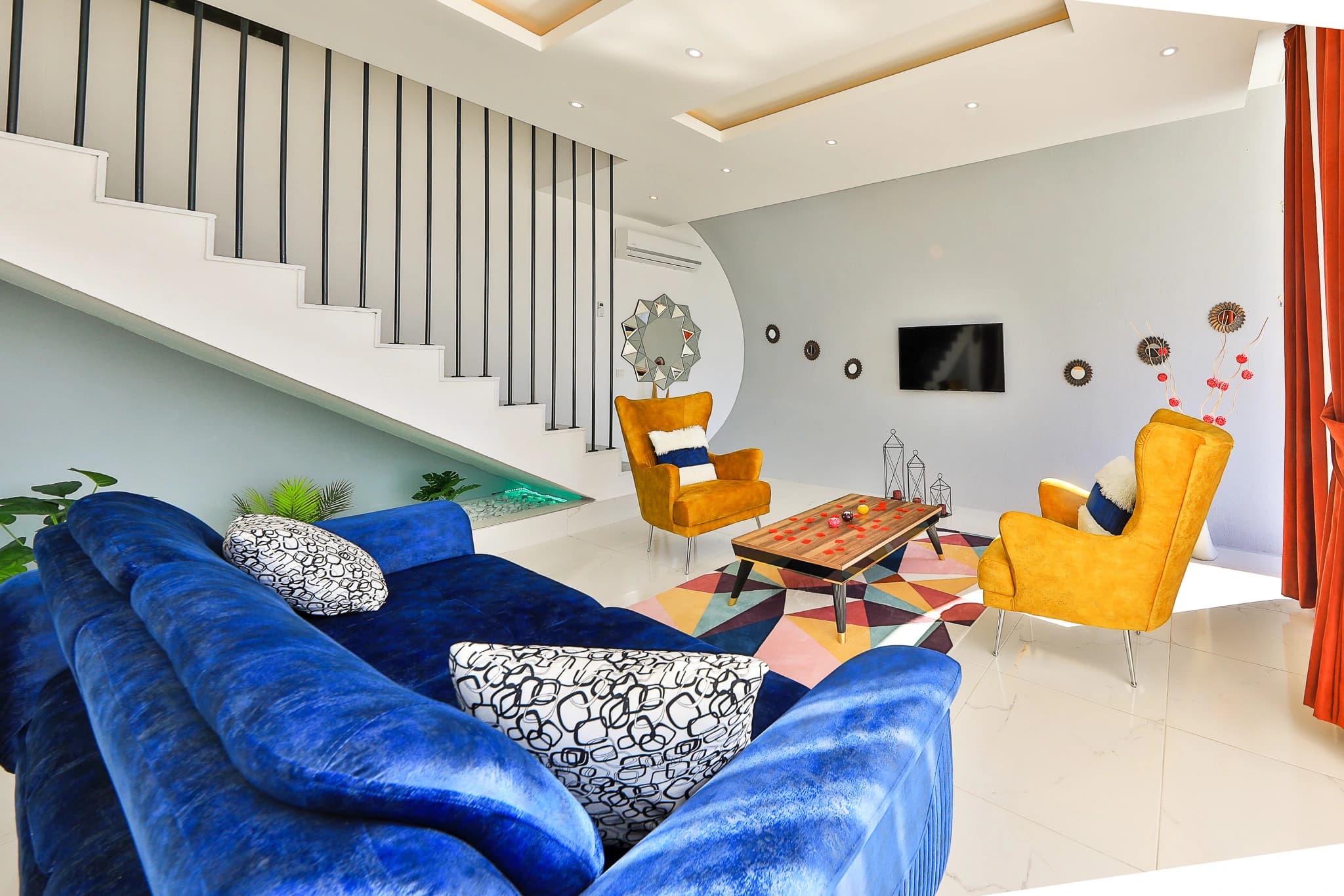 Living room with sunken seating area and contemporary stair design.