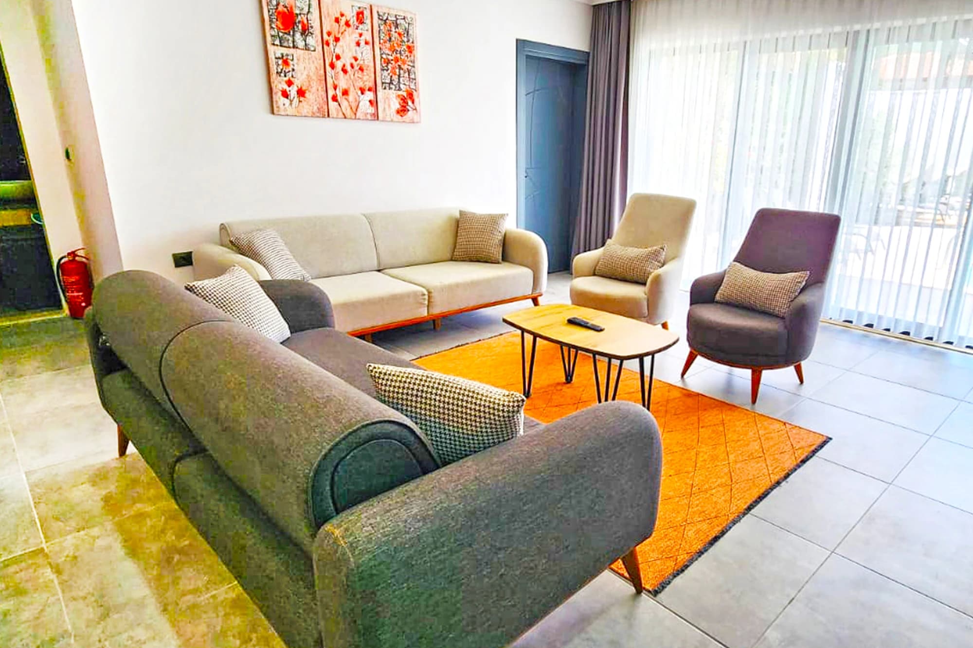 Modern living room with multiple seating areas and natural light.