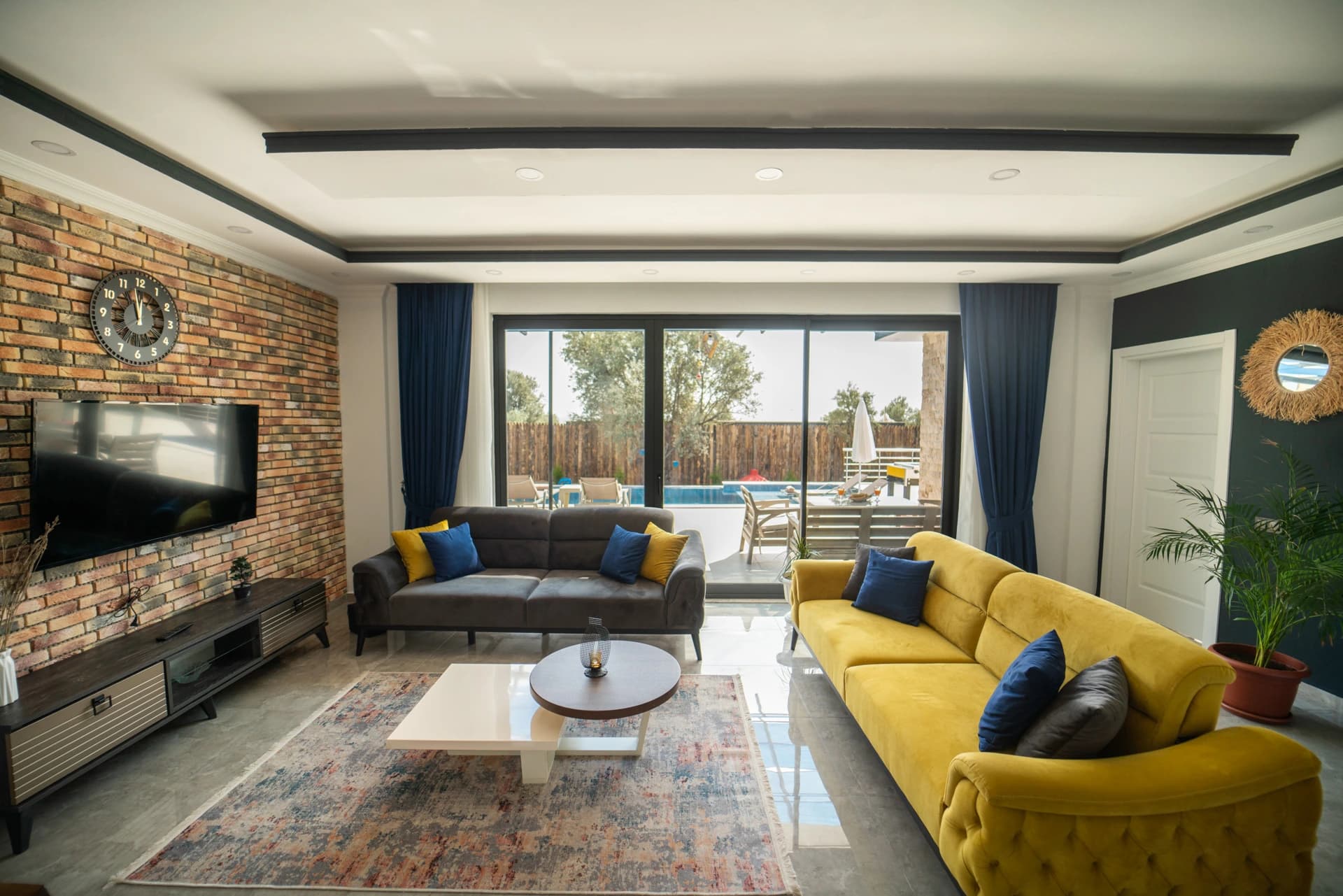 Elegant living room with multiple seating areas, fireplace accent, and direct access to pool terrace.